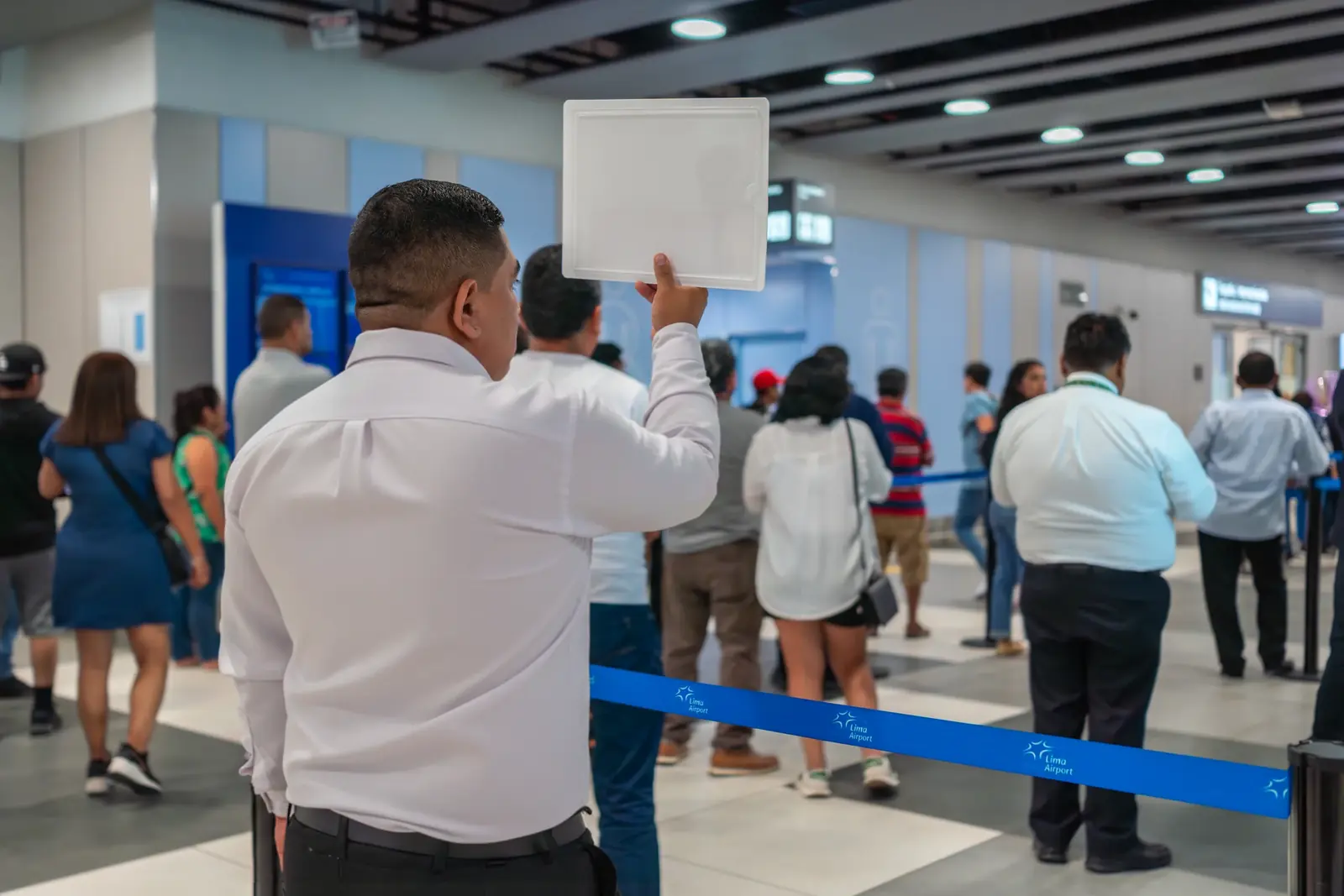 Conductor de Suisper con un cartel en llegadas del aeropuerto Jorge Chávez