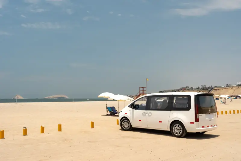 Van Suisper en una playa con islas al fondo