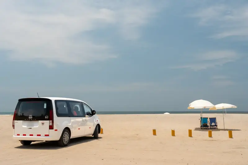 Van Suisper en una playa del sur de Lima con sombrillas